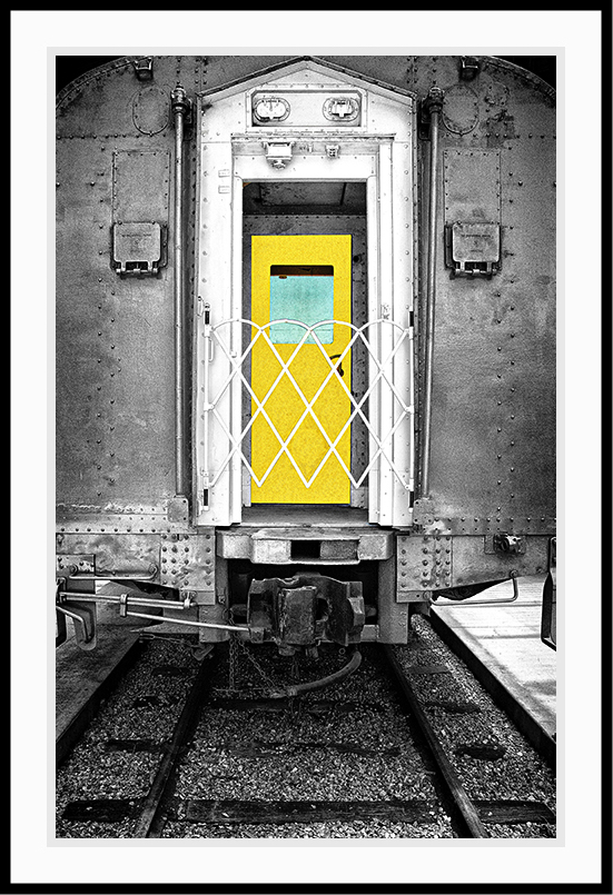 Train car in black and white with a yellow door.